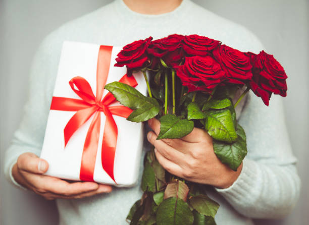 Handsome Man Holding Bouquet Of Beautiful Red Roses In Hand